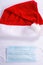 Santa hat with a protective mask on a white background, top view. christmas coronavirus concept