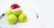 Santa hat on tennis ball, set of tennis balls on racket on white snow winter background. Merry Christmas and New year concept with