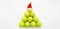 Santa hat on tennis ball on white snow background. Christmas and New year concept with tennis balls. Yellow green color tennis