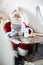 Santa Holding Digital Tablet In Private Jet