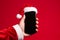 Santa holds a blank smartphone in his hand. Santa hat mockup phone template. Generative AI