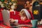 Santa little helper. Little boy santa hat and costume having fun. Boy child with laptop near christmas tree. Buy