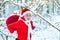 Santa in red suit walking along the road to Christmas. Santa Claus with a huge bag. Santa Claus comes with gifts from