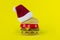 Santa\'s Cap with Toy burger on yellow background. Christmass fast food. Gift wrapped hamburger.