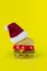 Santa\\\'s red hat on Plastic hamburger in form christmass tree on yellow background. Santa Claus loves to eat fast food