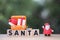 Santa text on wooden block with gift box in suitcase