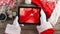 Santa using tablet with Christmas snowflakes