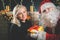 Santa and woman near the decorated Christmas tree. Wishes list