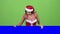 Santa woman peeking out from behind a blue board and showing ok. Green screen