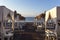 Santorini black beach Perissa, Perivolos illuminated by the morning rays of the sun. Luxurious wooden beds with white pergola and