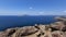 Santorini, Caldera, view from the rocky coastline of the Caldera and two volcanic islands .In the background Oia. Beautiful clear