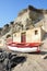 Santorini, Greece: a fisherman boat under the volcanic cliffs