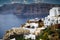 Santorini  Greece: Wide angle shot of cityscape showing White houses built on mountain against beach and mountains during summer