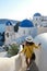 Santorini Greece, woman on luxury vacation Oia Santorini Island greece visit the white village with beautiful building