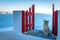 Santorini island, Greece: Landmark detail of a gate with a beautiful cat over the caldera Caldera