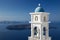 Santorini - tower of Anastasi church in Imerovigli with the Nea Kameni island in background.