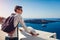 Santorini traveler man enjoying Caldera view from Fira or Thera, Greece. Tourism, traveling, vacation concept