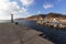 Santorini - the village of Thira, a beautiful bay with a boat harbor surrounded by high rocks. There is a lighthouse at the left