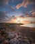 Sanur beach covered in rocks surrounded by the sea during the sunrise in Bali, Indonesia