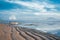 Sanur sandy beach at dawn. Low tide on the beach. Boat at the shore against the background of mountains and a volcano.