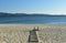 Sanxenxo, Spain. October 2018. Two women are resting and looking at the view on a beach boardwalk. Sunset, sunny day.