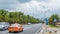 Sanya, China - May 15, 2019: Road traffic. A lot of electric cars. Hybrid buses. 90 percent of mopeds are electric