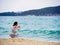 SANYA, HAINAN, CHINA - 4 MAR 2019 - Young Asian Chinese woman tourist snaps a photo at the beach with copy space