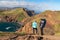 Sao Lourenco - Couple with baby carrier looking at majestic Atlantic Ocean coastline at Ponta de Sao Lourenco peninsula, Canical