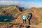 Sao Lourenco - Couple with baby carrier looking at majestic Atlantic Ocean coastline at Ponta de Sao Lourenco peninsula, Canical