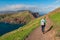 Sao Lourenco - Hiker woman with panoramic view of majestic Atlantic Ocean coastline at Ponta de Sao Lourenco peninsula, Canical