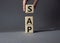 SAP - Systems Applications Products. Wooden cubes with word SAP . Businessman hand. Beautiful grey background. Business and System