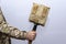 A sapper shovel in a closed case in the hand of an American military on a light background.