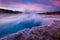 Sapphire Pool in Biscuit basin with blue steamy water and beautiful colorful sunset. Yellowstone, Wyoming