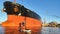 A sapsurfer swims in front of a huge tanker in the port of St. Petersburg.
