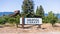 Saratoga Library sign; building visible behind, surrounded by fruit trees; San Francisco Bay Area, California