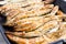 Sardines being prepared with sea salt on a barbecue grill hotpl