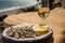 Sardines espeto prepared on skewers and open flame on fireplace with olive trees wood, served outdoor with glass of fino sherry