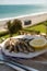 Sardines espeto prepared on skewers and open flame on fireplace with olive trees wood, served outdoor and view on blue sea, Malaga