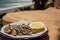 Sardines espeto prepared on skewers and open flame on fireplace with olive trees wood, served outdoor and view on blue sea, Malaga