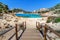 Sardinia, holidays, beautiful beaches of the archipelago of La Maddalena, a wooden bridge leading to the beach.