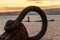 Sardinia. Portoscuso. Sunset on the Canale di San Pietro. The lighthouse Sa Ghinghetta framed by the ring of an ancient anchor