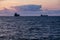 Sardinia. Portoscuso. Sunset on the sea of the Canal of St Peter. Two cargo ships anchored in the harbor