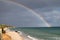 Sardinian coast, rough sea and cloudy sky after the rain with a rainbow that is born on the sea. Rainbow over the sea after a