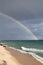 Sardinian coast, rough sea and cloudy sky after the rain with a rainbow that is born on the sea. Rainbow over the sea after a