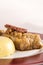 Sarmale,  a traditional Romanian stuffed cabbage dish,  served with polenta,  bacon and hot chilli,  placed on a white and red