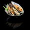 Sashimi with mussels in a black plate. On a black background wit