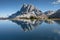 Sass de Putia reflects itself over a small alpine lake in Dolomites at evening