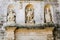 Sassi di Matera. Medieval sculptural group of three figures on the pediment of the seminary building