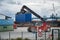 Sassnitz-Mukran, Germany, August 20, 2020: Red shunting vehicle is moving a heavy blue container in the industrial cargo port of