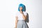 Sassy coquettish asian girl in blue wig have a secret, winking and shushing at camera with sensual expression, wearing